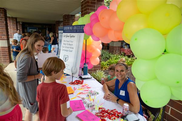 PTO member smiling with neon balloons